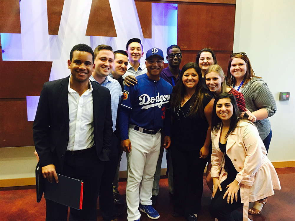  STHM undergraduates Madelyn McDonnell (back row, far right) and Anika Singh (first row, far right) pose for a photograph with Los Angeles Dodgers manager Dave Roberts during the SABR Analytics Conference in Phoenix, Ariz.