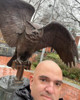 Man in foreground with statue of eagle behind him